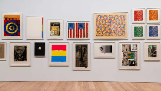 Gallery wall displaying colorful abstract and patriotic prints by Jasper Johns with wood floor