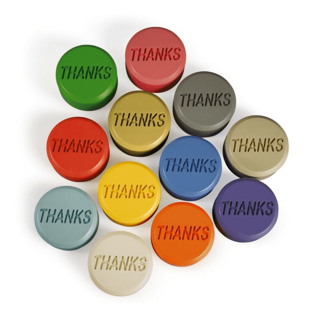 Colorful round tokens embossed with the word THANKS in various pastel and bright colors arranged in rows